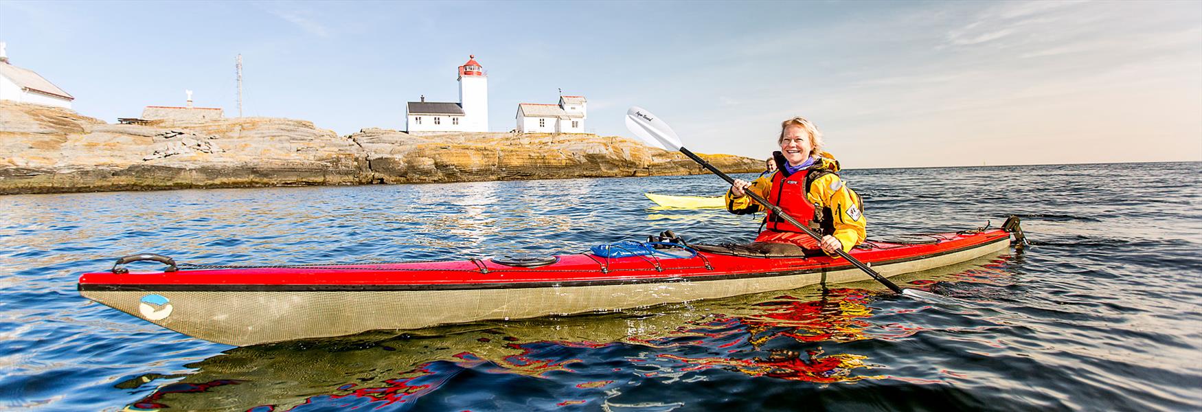 lady paddling past Langesund lighthouse