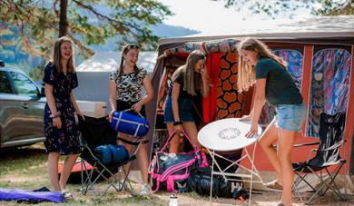 girls unpack tents and equipment at Telnessanden camping