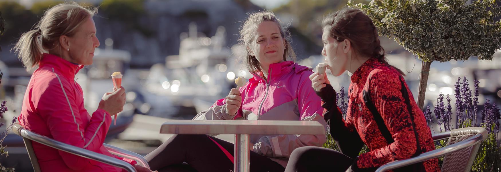 3 ladies sit around a table and eat ice cream