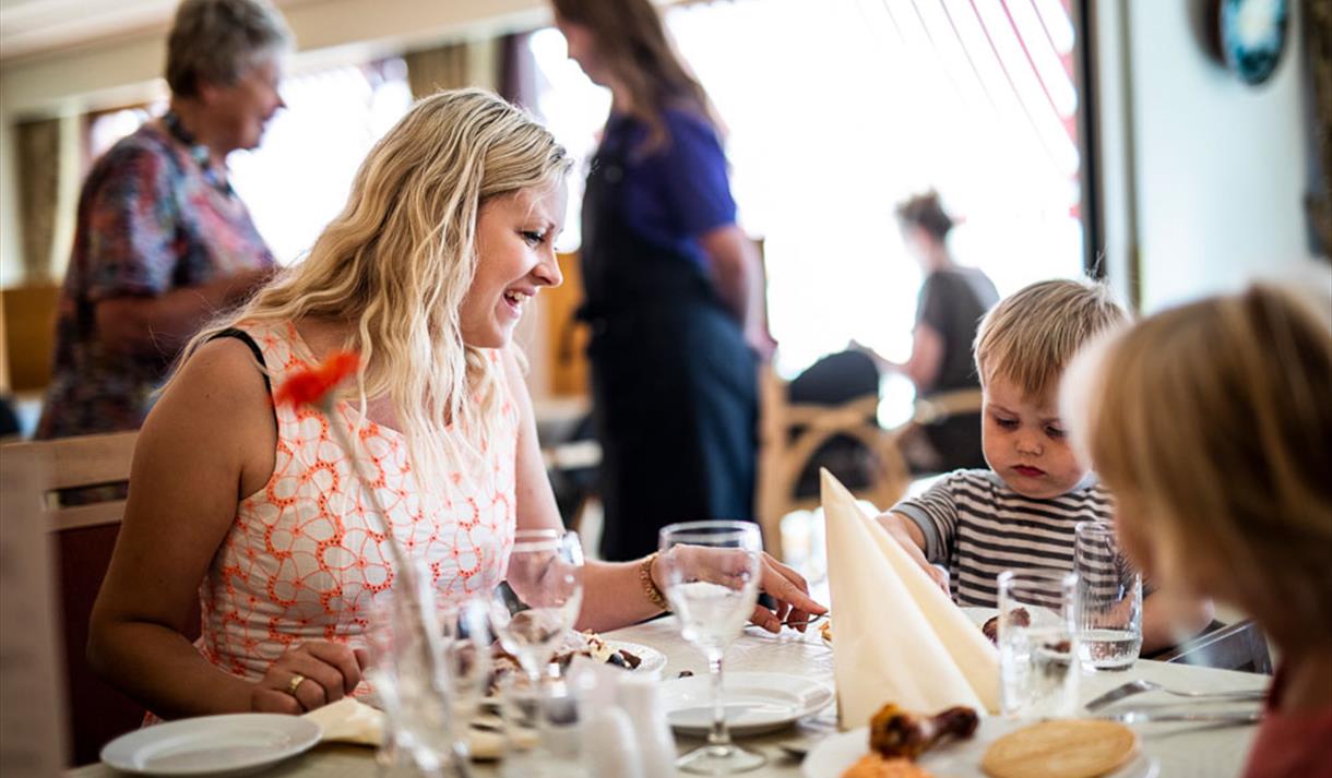 mother and child sitting in restaurant at Straand Hotel