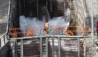 cyclists roll their bikes over the lock