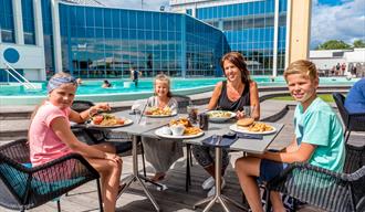 family eats on the terrace by the bathing park at Quality Hotel Skjærgården