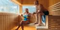 Couples enjoy the view out towards Hjartsjå in the sauna.