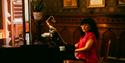 A lady is sitting at the piano at the Dalen Hotel