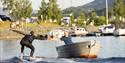 man on an electric surfboard and man in a boat