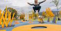 Boy jumping on trampoline in activity park.
