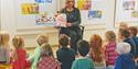 lady reading book to children at library