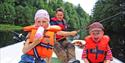 man and 2 children sitting in a boat