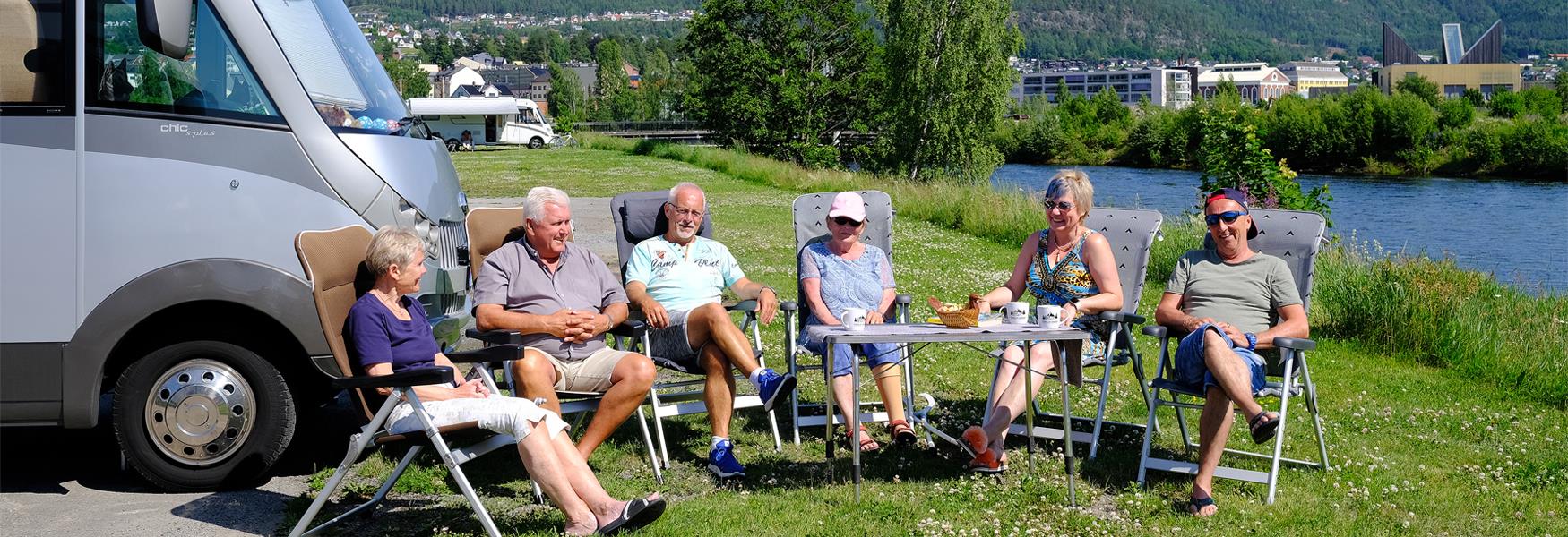 group of pensioners sitting in front of a mobile home
