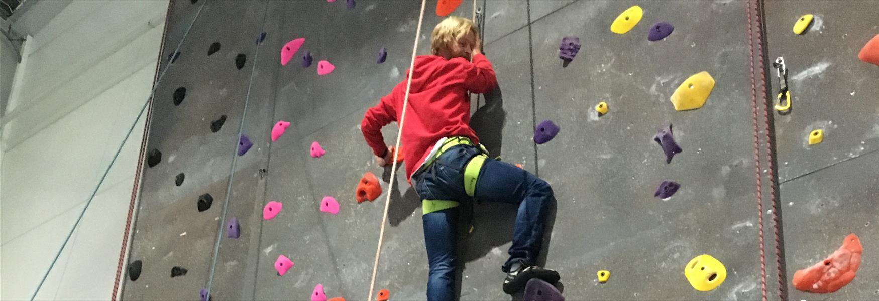 lady climbs on an indoor climbing wall