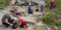 Children dig in the archeological sandbox at Vest-Telemark Museum Eidsborg
