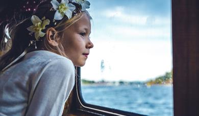 girl looks out of the window on the boat