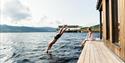 man jumps into the water from the deck of Dugg sauna in Notodden
