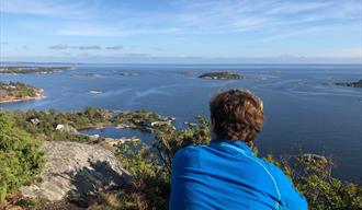 hiker looks out over the water from Vardås