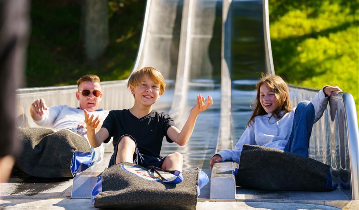 children sliding down a slide at Foldvik family park