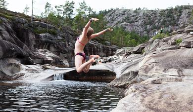 girl jumps in water in the giant pots in Nissedal