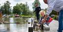 girl locks a boat on the miniature version of the telemark canal in the canal park at Vest-Telemark Museum in Eidsborg