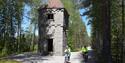 2 cyclists cycle past a tower on the cycle path "old Treungenbanen"