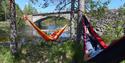 2 cyclists relax in their respective hammocks along the cycle path "old Treungenbanen"
